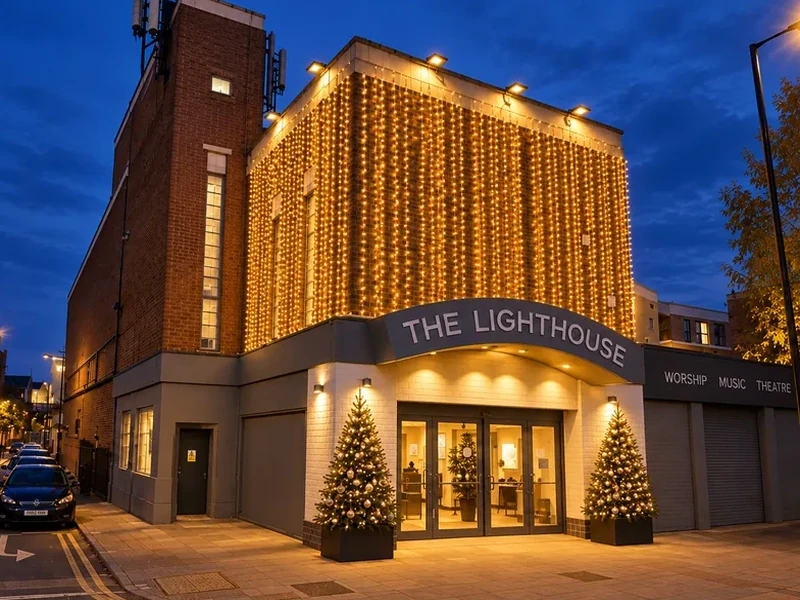 The same Camberwell building at blue hour with a curtain of warm white lights across the upper frontage
